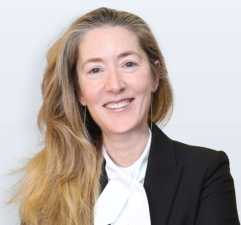 Head and shoulders photo of Andree Simon, smiling, wearing a black suit jacket and a white shirt.